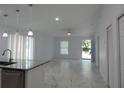 Open concept living area with marble-look floors and access to the kitchen at 10008 N 20Th St, Tampa, FL 33612