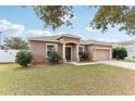 Beautiful single-story home with a manicured lawn and a classic front facade at 10757 Carloway Hills Dr, Wimauma, FL 33598