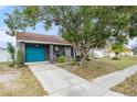 Gray house with teal garage door and driveway at 1232 Calamondin Dr, Holiday, FL 34691