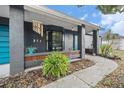 Front porch with teal door and landscaping at 1232 Calamondin Dr, Holiday, FL 34691