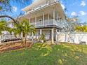 Two-story home with a wrap-around porch and lush landscaping at 1538 Riverside Dr, Tarpon Springs, FL 34689