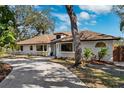 White single-story home with brown roof and lush landscaping at 1621 Park N St, St Petersburg, FL 33710