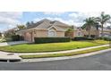 Well-maintained home with a three-car garage, lush landscaping, and manicured lawn on a corner lot at 1642 Daylily Dr, Trinity, FL 34655