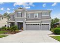 Two-story house with gray siding, three car garage, and well-maintained landscaping at 19322 Autumn Chase Ct, Land O Lakes, FL 34638