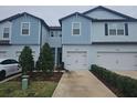 Two-story townhome with light blue siding, two-car garage, and landscaping at 19639 Shady Oak Dr, Land O Lakes, FL 34638