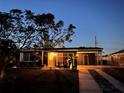 Night view of a ranch-style home with a dark facade and well-maintained lawn at 2311 Wellesley, Bradenton, FL 34207