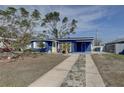 Charming blue house with a yellow door, offering a warm and inviting curb appeal at 2311 Wellesley, Bradenton, FL 34207