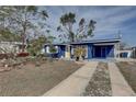 Attractive blue home with a bright yellow door and an inviting, well-maintained front yard at 2311 Wellesley, Bradenton, FL 34207