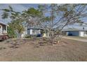 Charming blue house with yellow door and mature tree, framed by lush foliage at 2311 Wellesley, Bradenton, FL 34207