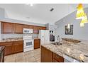 Updated kitchen featuring granite countertops, white appliances, and modern fixtures at 2653 Cover Ln, North Port, FL 34286