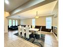 Elegant dining room with modern light fixture and seating for eight at 4110 Huntingdale Ct, Wesley Chapel, FL 33543