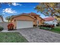 Tan house with a white garage door and a nicely landscaped front yard at 5232 White Sand Ne Cir, St Petersburg, FL 33703