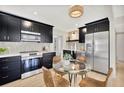 Modern kitchen with stainless steel appliances and glass dining table at 664 60Th S St, St Petersburg, FL 33707