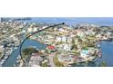 Aerial view of the coastal neighborhood with picturesque canals, docks, boats, and waterfront homes under a sunny sky at 6702 Harbor Dr, Hudson, FL 34667