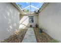 Private courtyard with stone pathway and gravel, leading to a charming entrance at 7408 Trovita Rd, Land O Lakes, FL 34637