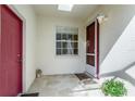 Welcoming front porch with tiled flooring and a red front door, creating an inviting entry at 7408 Trovita Rd, Land O Lakes, FL 34637