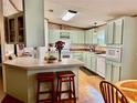 Kitchen with island, light green cabinets, and wood flooring at 8326 Fantasia Park Way, Riverview, FL 33578