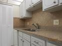 Kitchen with granite countertops, light wood cabinets, and a double sink at 1235 S Highland Ave # 3-303, Clearwater, FL 33756