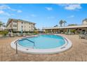 Community pool with surrounding lounge chairs and patio umbrellas at 1235 S Highland Ave # 3-303, Clearwater, FL 33756