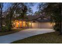 Inviting home exterior at dusk with warm lighting and a spacious driveway at 170 Greenhaven Cir, Oldsmar, FL 34677