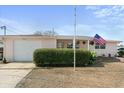 Single story home with attached garage and manicured hedges at 2333 Tahitian Dr, Holiday, FL 34691