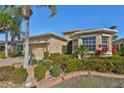Tan one-story house with palm trees and landscaped yard at 335 Siena Vista Pl, Sun City Center, FL 33573