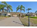 Tan one-story house with palm trees and landscaped yard at 335 Siena Vista Pl, Sun City Center, FL 33573