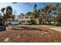 Charming two-story home with a front yard adorned with mature trees and a welcoming entrance, giving a cozy curb appeal at 346 80Th Ne Ave, St Petersburg, FL 33702