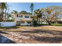 Inviting two-story home with classic shutters, a covered entrance, and a yard dotted with trees at 346 80Th Ne Ave, St Petersburg, FL 33702