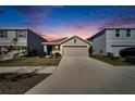 House exterior at dusk with driveway and landscaping at 5322 Fiddle Fig Ave, Wimauma, FL 33598