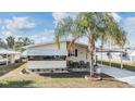 Inviting single-story home with covered awning, front patio seating and decorative palm tree at 5539 Regal Way, Zephyrhills, FL 33541