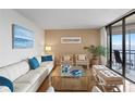 Inviting living room featuring a comfortable sofa, stylish decor, and sliding doors to a balcony with water views at 5633 Puerta Del Sol S Blvd # 306, St Petersburg, FL 33715