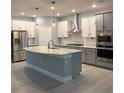 Modern kitchen featuring stainless steel appliances, an island, and two-tone cabinets at 6035 Plover Meadow St, Lithia, FL 33547