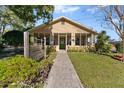 Tan house with green door, walkway, and landscaping at 931 And 925 Florida Ave, Palm Harbor, FL 34683