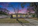 Charming home featuring a well-manicured lawn and a welcoming walkway at twilight at 1002 7Th S St, Safety Harbor, FL 34695