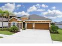 House exterior showcasing a three-car garage and well-manicured lawn at 1030 Tracey Ann Loop, Seffner, FL 33584