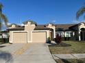 Attractive home showcasing its spacious two-car garage, complemented by manicured landscaping at 13330 Ashbark Ct, Riverview, FL 33579