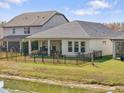 Spacious backyard with pond view, black fence, covered patio, and manicured lawn at 4927 Rolling Green Dr, Wesley Chapel, FL 33543