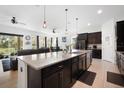 Open-concept kitchen with dark cabinets, granite countertops, and island with seating at 4927 Rolling Green Dr, Wesley Chapel, FL 33543