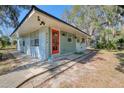 Quaint light blue home with orange door and landscaping; located on a quiet street at 6119 Beacon Point Dr, Weeki Wachee, FL 34607