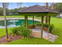 Charming gazebo with seating overlooking a serene pond with fountain at 1007 Lakewood Dr, Brandon, FL 33510