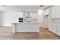 Stylish kitchen featuring white cabinets, a center island with countertop seating, and stainless steel appliances at 1219 Kazaz Ct, Zephyrhills, FL 33540