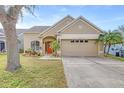 Tan one-story house with a two-car garage and landscaping at 12705 Bramfield Dr, Riverview, FL 33579