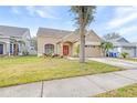 Tan one-story house with a two-car garage and landscaping at 12705 Bramfield Dr, Riverview, FL 33579