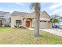 Tan one-story house with a two-car garage and landscaping at 12705 Bramfield Dr, Riverview, FL 33579