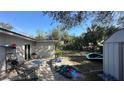 Backyard patio with outdoor furniture, grill, and access to the yard; some items are scattered at 13634 Twig Ter, Largo, FL 33774