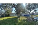 Single-story home with a mature shade tree in the front yard, adjacent to a blue car at 13634 Twig Ter, Largo, FL 33774