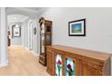 Elegant hallway showcasing wood floors, decorative cabinet, grandfather clock and decorative artwork at 14607 Turning Leaf Ct, Tampa, FL 33626