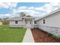 Close-up of the home's entry with attractive landscaping and a well-manicured lawn at 15422 Wine Dr, Weeki Wachee, FL 34614