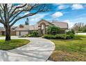 Charming single-story home with lush landscaping, and a spacious driveway leading to a two-car garage at 16908 Equestrian Trl, Odessa, FL 33556